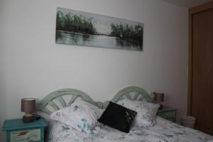 1 dormitorio con 1 cama y una foto en la pared en Apartamento Ronda San Antón en Toro