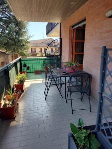 a patio with a table and chairs on a balcony at Bilocale con ampio terrazzo in Bra