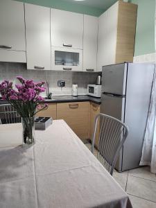 a kitchen with a table with a vase of purple flowers at Bilocale con ampio terrazzo in Bra