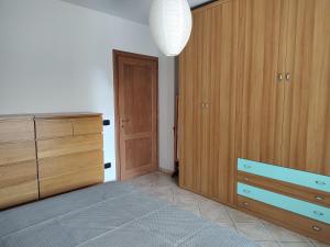 1 dormitorio con armarios de madera, vestidor y puerta en Bilocale con ampio terrazzo en Bra