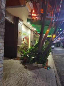 a building with a tree on the side of a street at MOTEL WIN - PHÁT in Bien Hoa +7 photos