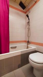 a bathroom with a toilet and a pink shower curtain at Hotel Palace Masoanri's in Reggio di Calabria