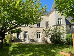 uma grande casa branca com um grande quintal em Closerie la Fontaine em Savigné-sur-Lathan