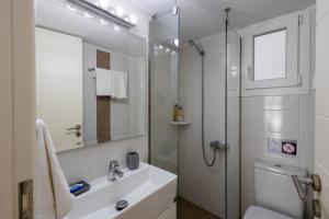 a white bathroom with a sink and a shower at Lydia's East Apartment in Aliki +55 photos