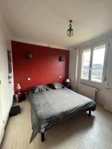 um quarto com uma cama grande e uma parede vermelha em Dame Salamandre em Concarneau