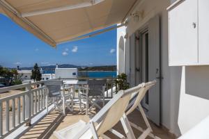 a balcony with chairs and a table and a view of the ocean at Lydia's East Apartment in Aliki