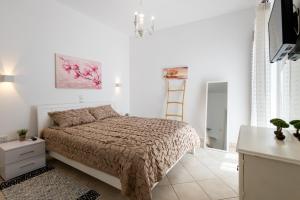 a bedroom with a bed and a white wall at Lydia's East Apartment in Aliki