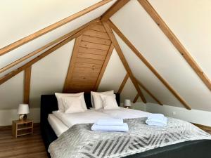 a bedroom with a white bed in an attic at Bąbelkowa Chata Beskidy in Gilowice