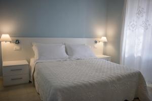 a bedroom with a white bed with white sheets and pillows at Casale Al Solivo B&B in Castion Veronese