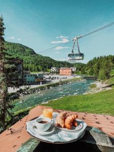 a plate of food on a table next to a river at Hotel Nolda in St. Moritz