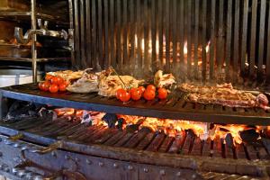 a grill with some meat and tomatoes on it at Grand H&ocirc;tel de l'Abbaye in Beaugency
