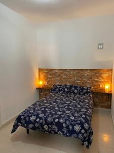 Fasnia的住宿－Casa Enedina，卧室配有一张床,墙上有两盏灯