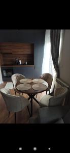 una habitación con 2 mesas y sillas y una cocina en Apartman I&N, en Zlatibor