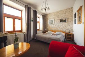 1 dormitorio con 1 cama y 1 mesa en una habitación en Penzion U Papoušků en Jindrichuv Hradec