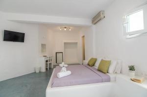 a bedroom with a large bed in a white room at Sunrise Hotel in Ios Chora