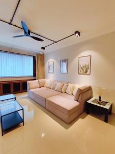 een woonkamer met een bank en een plafondventilator bij Wisma Cosway-2mins Pavillion & KLCC by Abby Stay in Kuala Lumpur