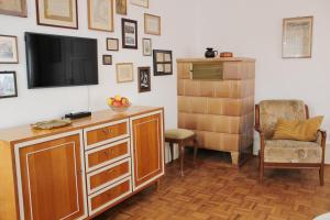 a living room with a flat screen tv and a chair at Ferienwohnung Sommerberg, Lenzkirch, 2 Schlafzimmer in Lenzkirch