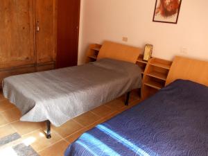 een kamer met 2 bedden, een tafel en een bureau bij settimana relax in Borghetto