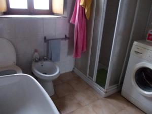 een badkamer met een wastafel en een wasmachine bij settimana relax in Borghetto