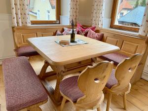 una mesa de madera con 2 sillas y una botella de vino en Altes Forsthaus - Fewo "Hasenhorn", mit privater Sauna, Todtnau- Feldberg, en Todtnau