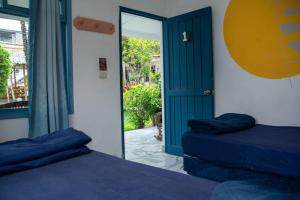 a room with two beds and a door to a patio at Casa Blanca - San Pedro in San Pedro La Laguna