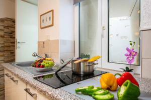 a kitchen with a stove top with vegetables on the counter at Apartman u srcu antičke Pule in Pula +36 photos