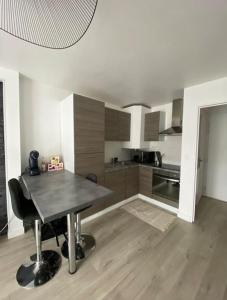 a kitchen with a table in the middle of a room at Le Cottage Apaisant in Ardon