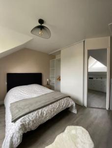 a bedroom with a bed and a large window at Le Cottage Apaisant in Ardon