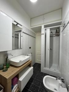 y baño blanco con lavabo y ducha. en L'host in Taormina en Taormina