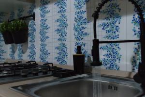 a kitchen sink with blue and white tiles on the wall at L'host in Taormina in Taormina +47 photos
