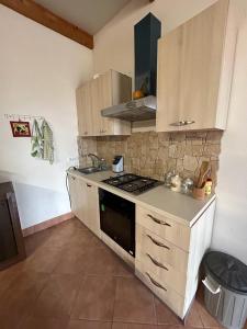 a kitchen with wooden cabinets and a stove top oven at Casa vacanze Daunisi in Marsala