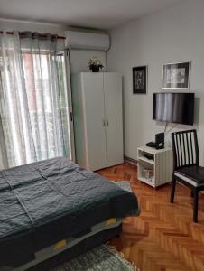 1 dormitorio con 1 cama, 1 silla y 1 armario en Apartman JELENA M Vrnjačka Banja, en Vrnjačka Banja