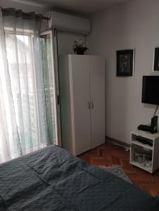 Un dormitorio con una cama y un armario y una ventana. en Apartman JELENA M Vrnjačka Banja, en Vrnjačka Banja