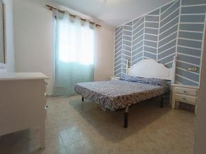 een slaapkamer met een bed en een blauwe muur bij Apartamento_Cala_Blanca in Alcossebre