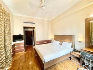 a hotel room with a bed and a television at HOTEL JANHVEE INN ! VARANASI - Forɘigner's Choice ! fully Air-Conditioned hotel with Parking availability, near Kashi Vishwanath Temple, and Ganga ghat in Varanasi