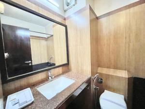 een badkamer met een wastafel, een toilet en een spiegel bij HOTEL JANHVEE INN ! VARANASI - Forɘigner's Choice ! fully Air-Conditioned hotel with Parking availability, near Kashi Vishwanath Temple, and Ganga ghat in Varanasi