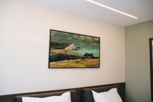 una pintura colgada sobre una cama en una habitación de hotel en Hotel Rozafa, en Suharekë