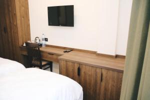 ein Schlafzimmer mit einem Schreibtisch und einem Fernseher an der Wand in der Unterkunft Hotel Rozafa in Suharekë + 13 Fotos