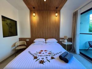 a bedroom with a large bed with a white bedspread at Serene Sky Guest house in Thoddoo