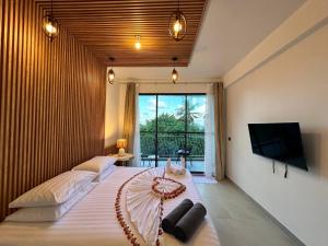 1 dormitorio con 2 camas y TV de pantalla plana en Serene Sky Guest house, en Thoddoo