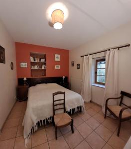 ein Schlafzimmer mit einem Bett, einem Stuhl und einem Fenster in der Unterkunft Gîte La Fournière de Costy in Agnac