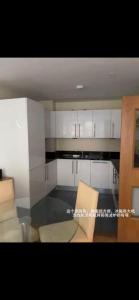a kitchen with white cabinets and a glass table at Convenient 2 BDR 2BA Flat in Central London in London