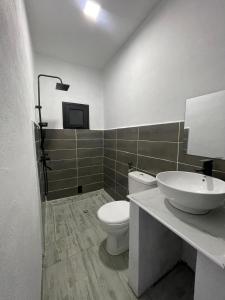 een badkamer met een wit toilet en een wastafel bij Dream's Hôtel in Antsirabe