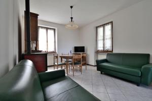 a living room with two green couches and a table at Casa Anna Tornolo Val di Taro in Tornolo