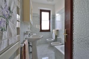 een witte badkamer met een wastafel en een toilet bij Casa Anna Tornolo in Tornolo