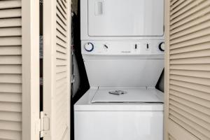 a white washer and dryer sitting in a closet at Stunning Condo with Wall-to-Wall Windows Overlooking Ocean in Myrtle Beach