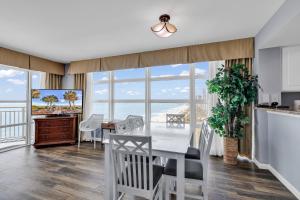 a kitchen and dining room with a table and chairs at Stunning Condo with Wall-to-Wall Windows Overlooking Ocean in Myrtle Beach