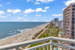 a view of the beach from the balcony of a condo at Stunning Condo with Wall-to-Wall Windows Overlooking Ocean in Myrtle Beach