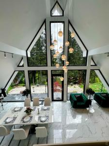 a dining room with a table and chairs and large windows at Pine Hill Poiana Marului in Poiana Mărului +26 photos
