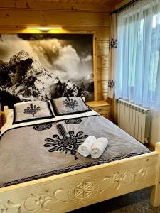 a bedroom with a bed with two towels on it at Apartamenty Smrekowka in Zakopane